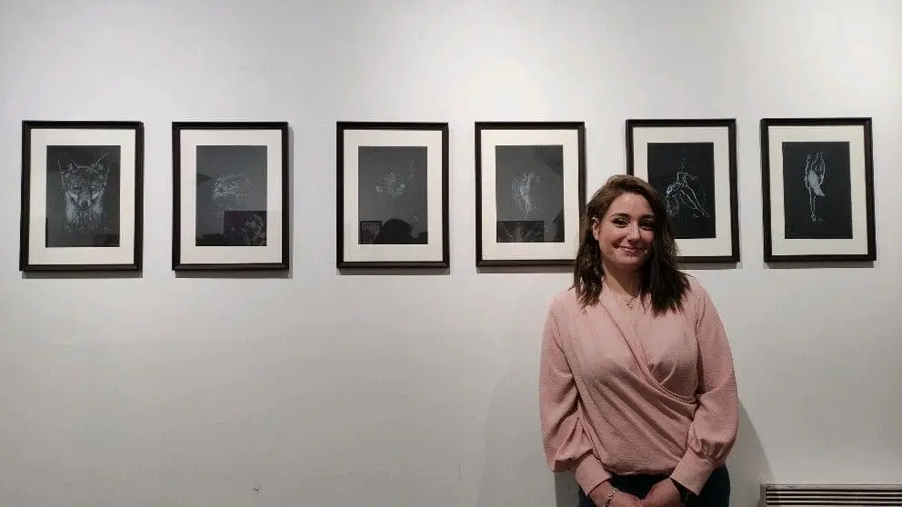 Portrait de l'artiste devant ses œuvres pendant l'exposition
